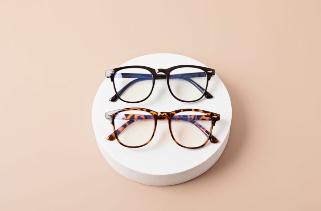 Two pairs of glasses sitting on a round podium.