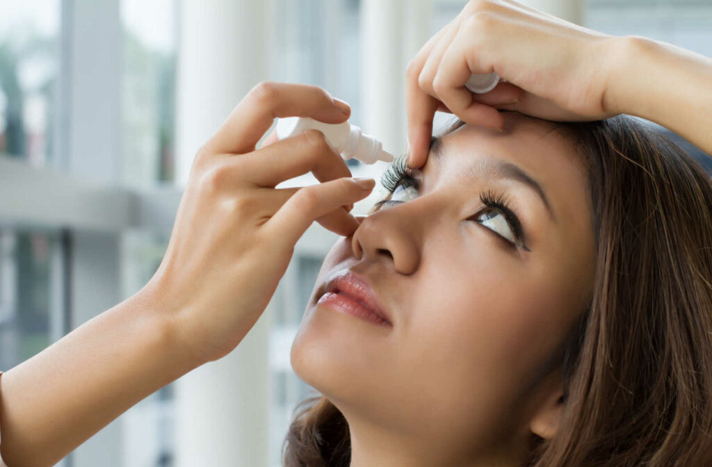 A woman using eye drops to treat her droopy eyelids.
