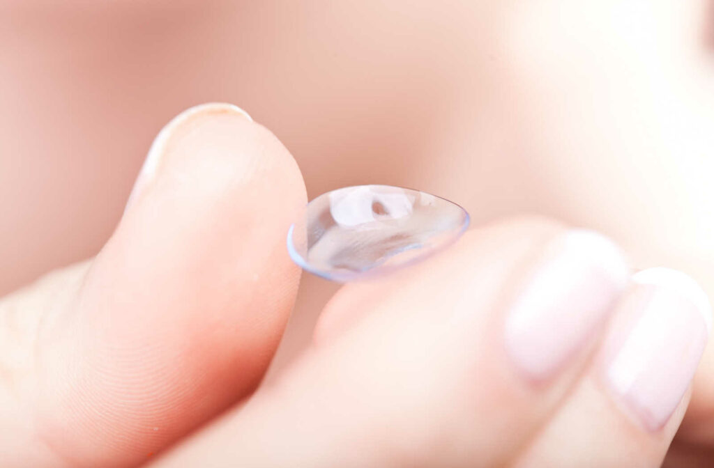 A close-up of a soft contact lenses for dry eyes is being held by a the hand.